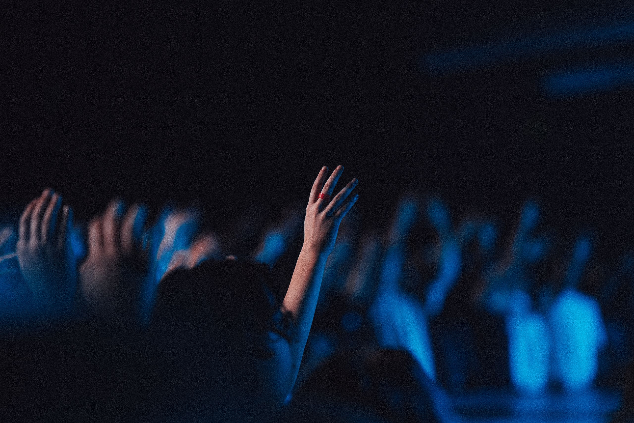 People in worship gathered in a hall with blue light effect